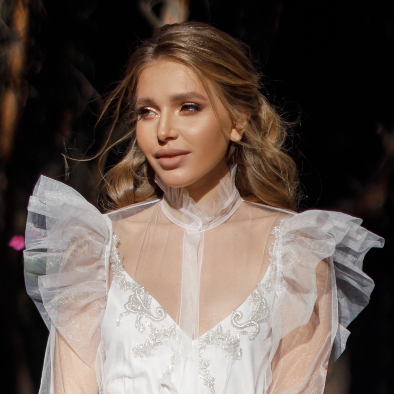Soft bridal makeup with glowing skin and loose waves for a wedding day
