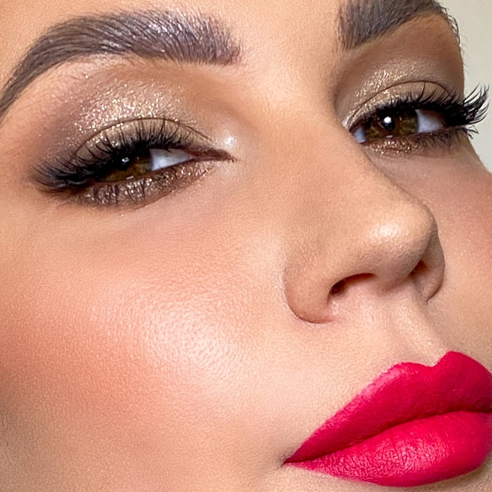 Close-up evening makeup with gold eyeshadow and a red lip